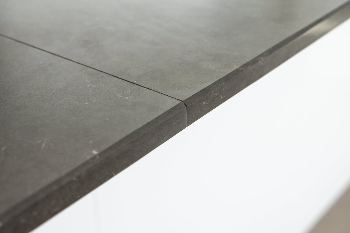 Close detail of a dark stone surface with a precise seam between sections